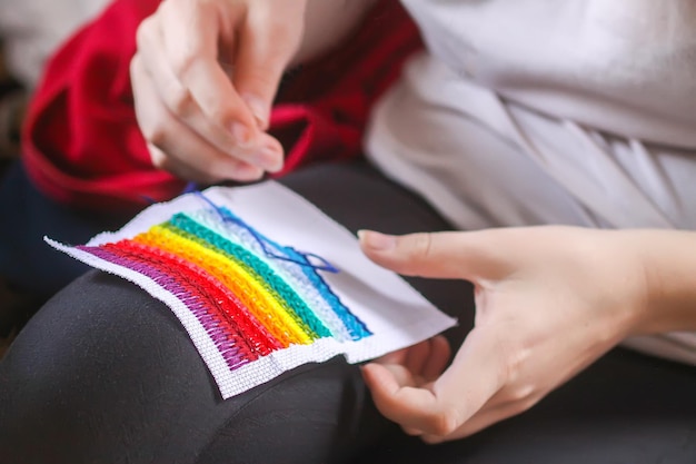 ręce trzymające haftowaną tkaninę